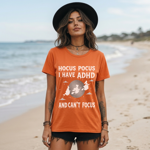 Woman on beach wearing orange Halloween shirt with funny Hocus Pocus I Have ADHD DTF transfer design.